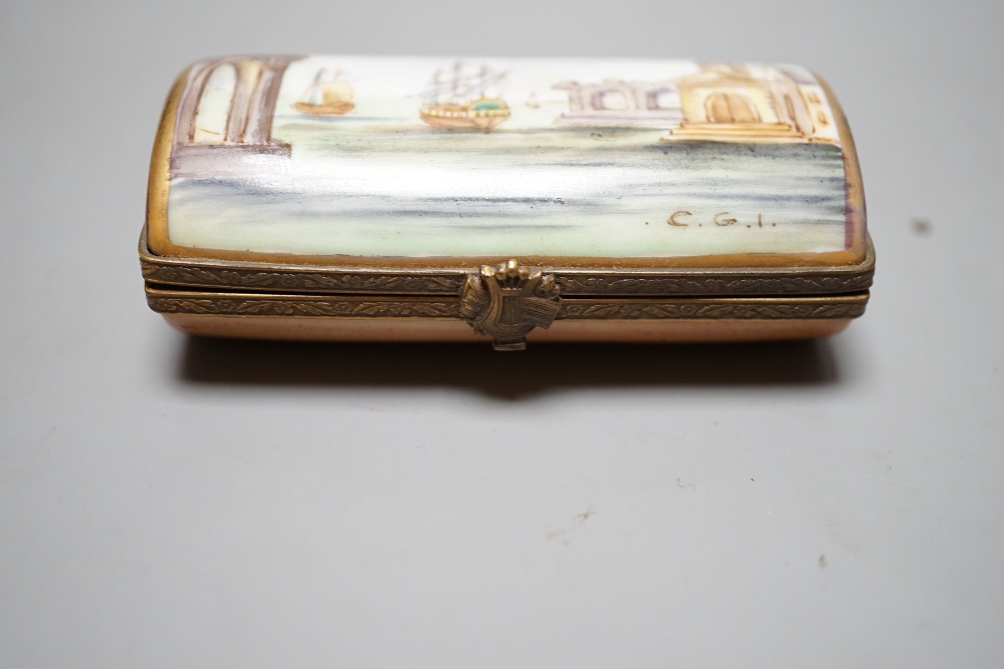 A Russian oval lacquered box, 10cm., and a porcelain box painted with ships approaching harbour